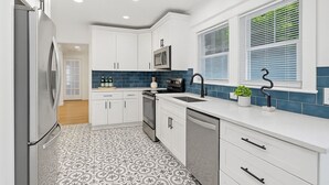 A modern kitchen with white cabinets, a stainless steel refrigerator, a microwave, and a sink. - <10mins 4rm Downtown, Early check-in, Pets welcome, With pool table (Atlanta)