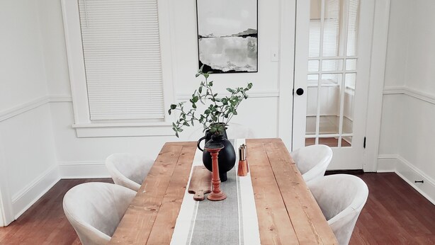 A dining room with a wooden table, white chairs, a vase with a plant, and a painting on the wall. - <10mins 4rm Downtown, Early check-in, Pets welcome, With pool table (Atlanta)