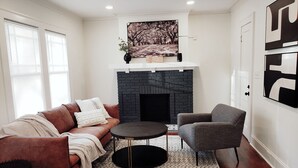 A living room with a fireplace, a sofa, a chair, and a rug. - <10mins 4rm Downtown, Early check-in, Pets welcome, With pool table (Atlanta)