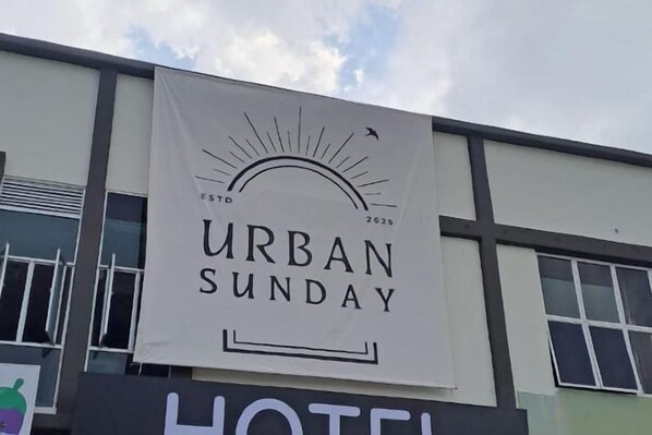 A building with a banner that reads 'URBAN SUNDAY' and a sign for a hotel. - Urban Sunday Jalan Langgar (langgar)