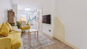 Un salon moderne avec un canapé, une table basse et un téléviseur fixé au mur.