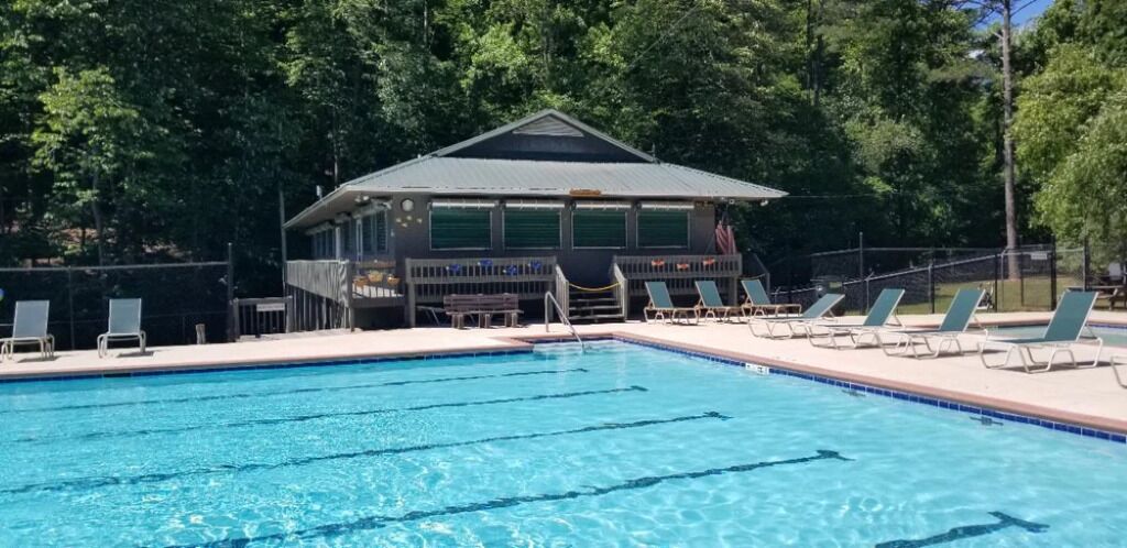 A swimming pool with lounge chairs and a building in the background.