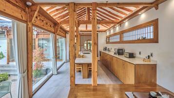 Una cocina moderna con vigas de madera, un ventanal grande y un área de comedor.