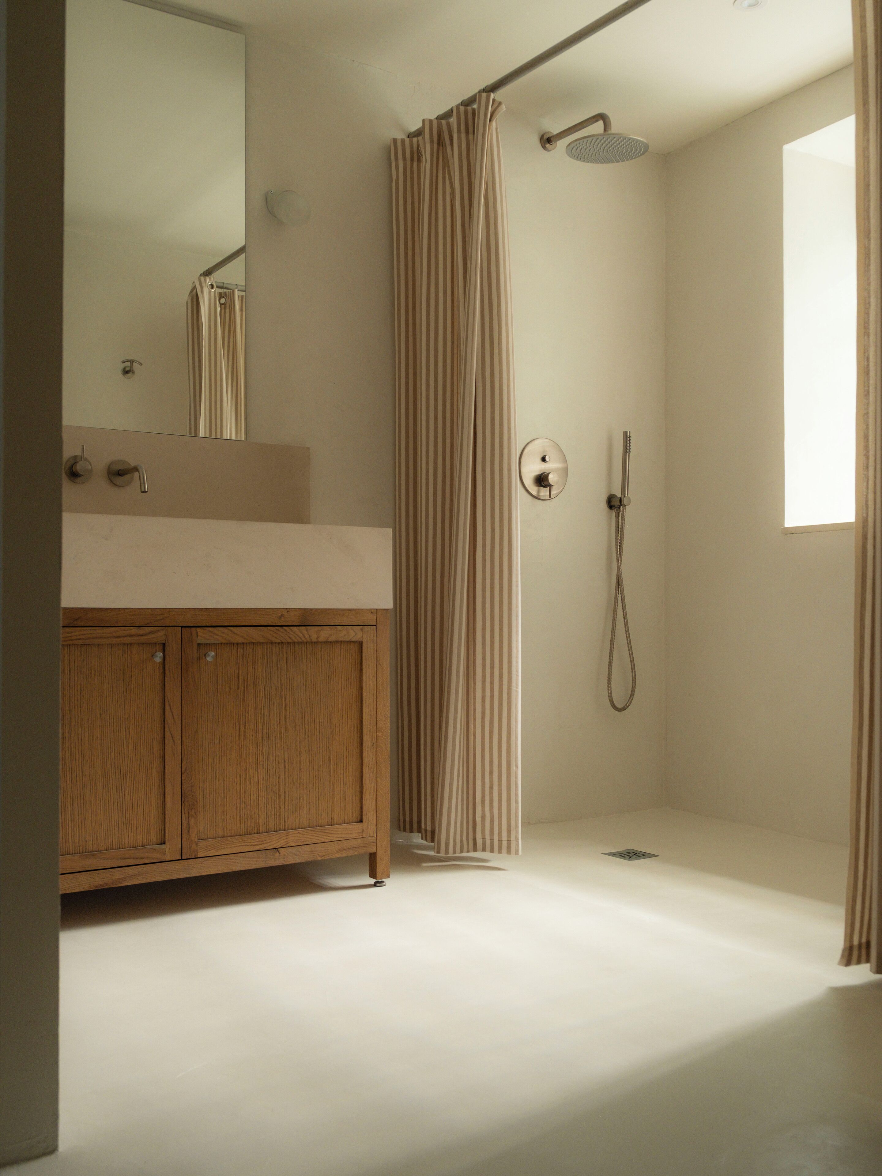 Une salle de bain moderne avec un meuble-lavabo en bois, une douche avec rideau et un grand miroir.