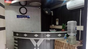 A reception area with a clock, a water dispenser, and a fan. - hotel shanavi Tower (Barasat)