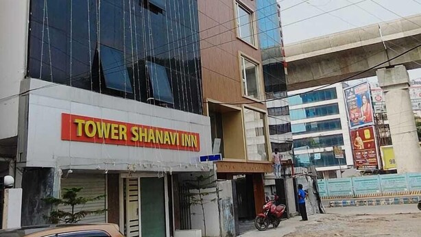 A multi-story building with a sign for 'TOWER SHANAVI INN' on the ground floor. - hotel shanavi Tower (Barasat)