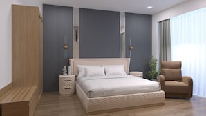 A modern bedroom with a large bed, bedside tables, a chair, and a wardrobe. - Playotel Grande Rau (Indore)