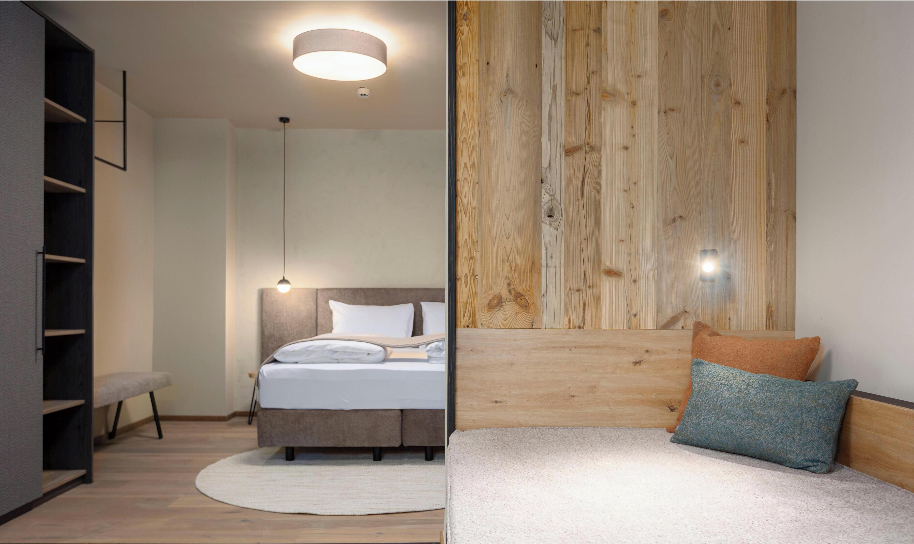 Une chambre à coucher moderne avec un lit, des tables de chevet et une tête de lit en bois.