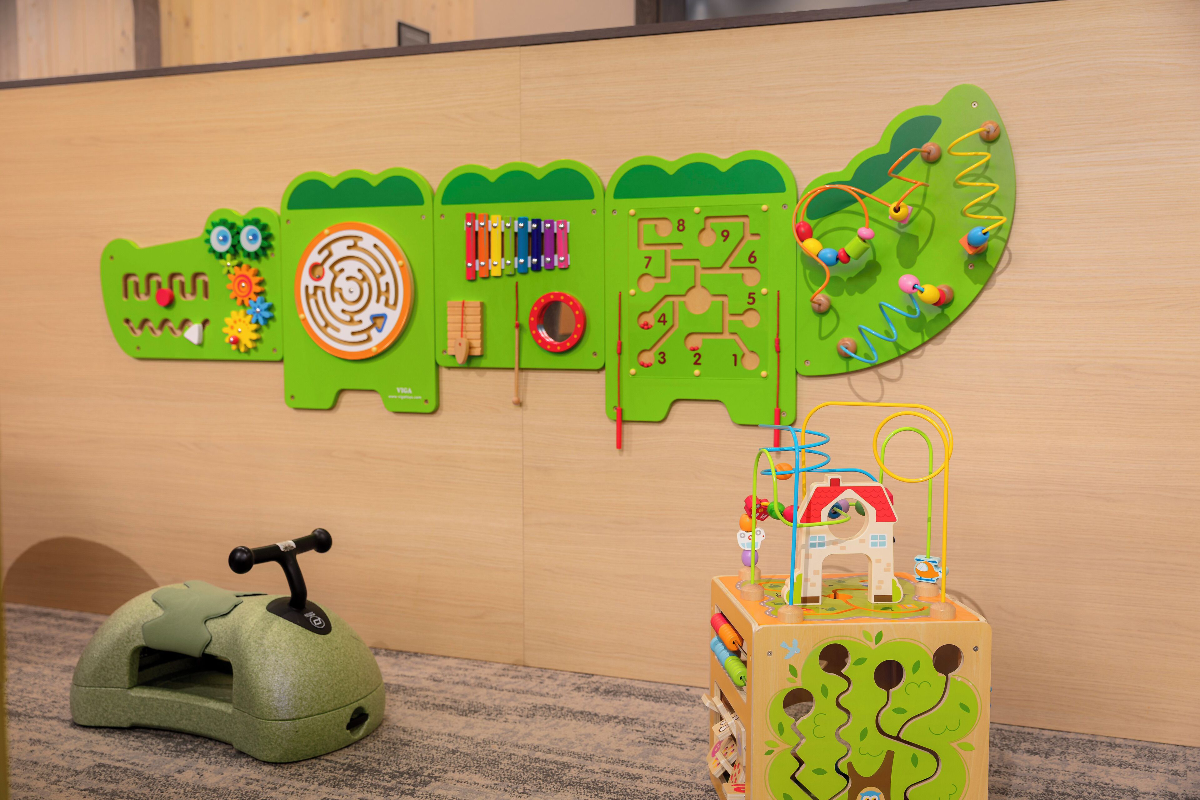 A play area with various educational toys and a green toy car.