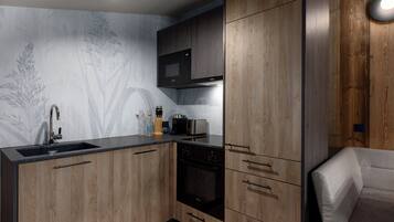 A modern kitchen with wooden cabinets, a built-in microwave, and a stainless steel sink.