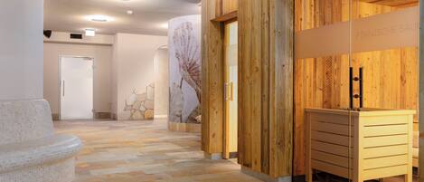 A modern interior with a wooden reception desk, a stone-tiled floor, and a minimalist design.
