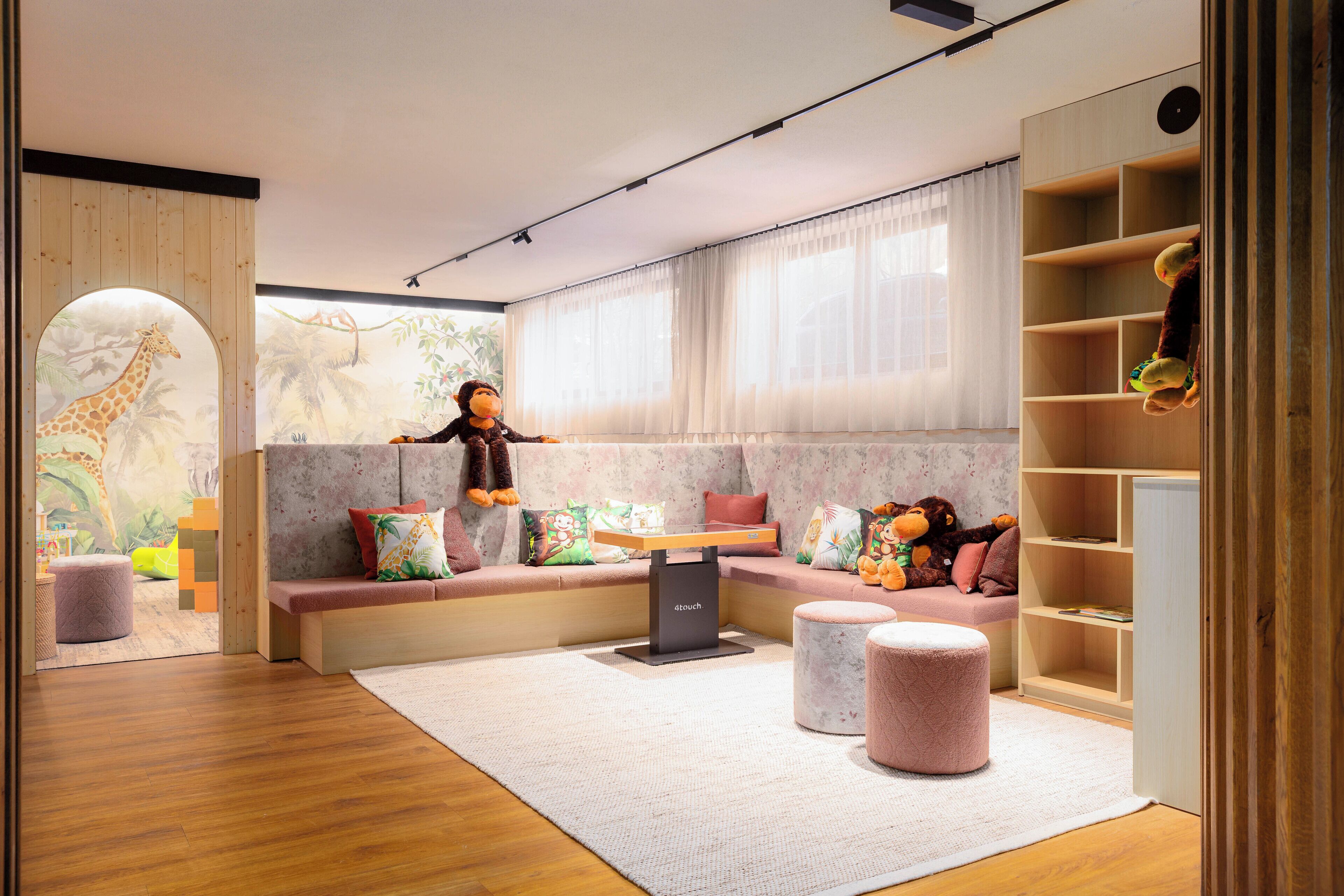 A children's playroom with a wooden bench, a table, and a bookshelf.