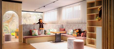 A children's playroom with a wooden bench, a table, and a bookshelf.