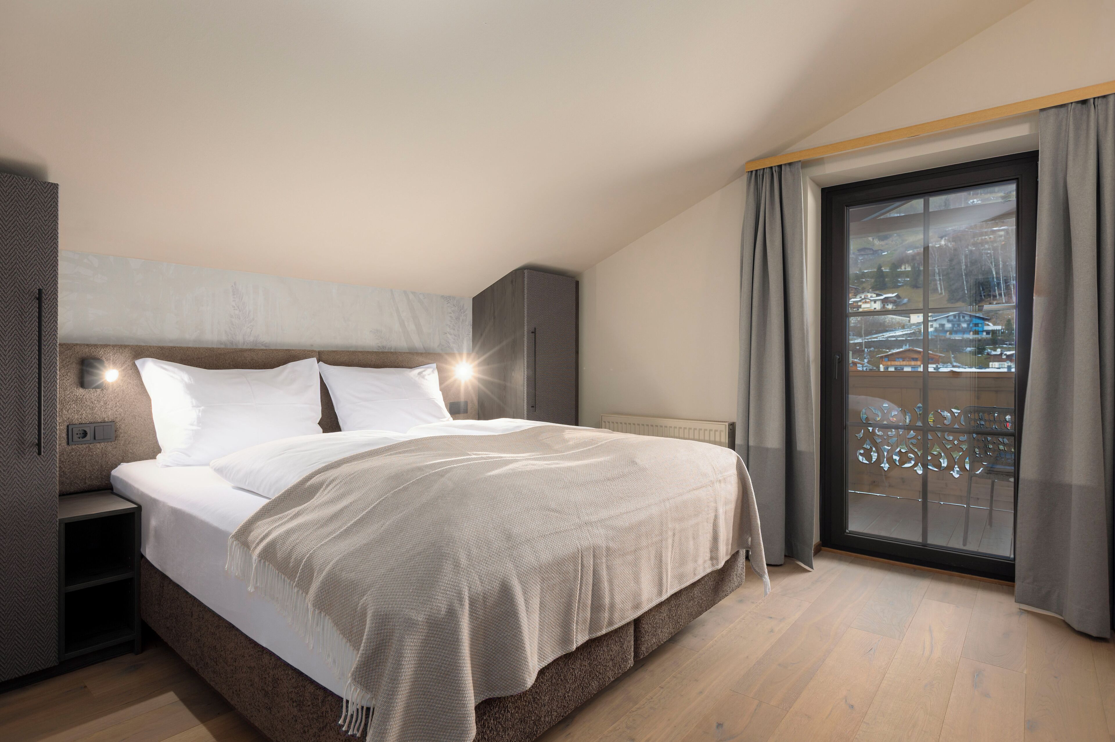 Un dormitorio moderno con una cama grande, una mesita de noche, un armario empotrado y una puerta corrediza de cristal a un balcón.