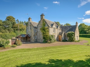 A stone house with a well-maintained lawn and a small outbuilding. - Winton Cottage - UK50380 (Pencaitland)