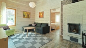 Una sala de estar moderna con chimenea, paredes de madera y una alfombra a cuadros.