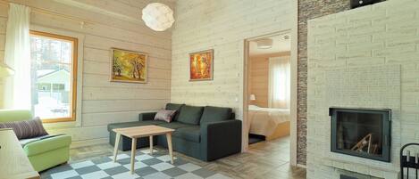 A modern living room with a fireplace, wooden walls, and a checkered rug.