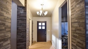 A hallway with a wooden wall, a dark door, and a ceiling light fixture. - Grand Sand Riverfront, private beach & boat dock (Parker)