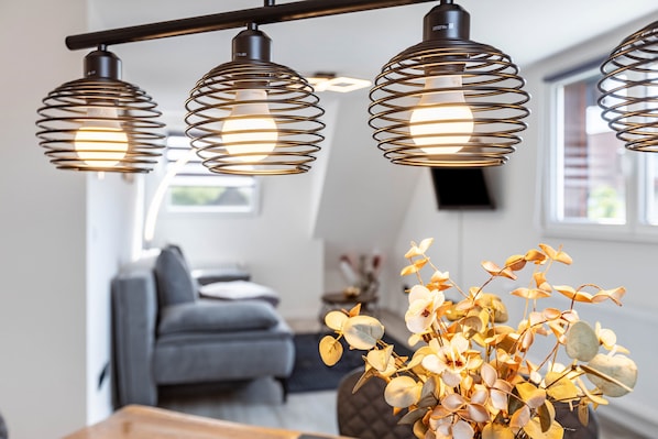 A modern interior with a sofa, a wooden table, and a vase with dried flowers. - Holiday Apartment "Auszeit Matzi" in a Quiet Location with Private Garden for Relaxation (Öhningen)