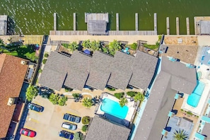 Un resort con varias cabañas, una piscina y un muelle que se adentra en el agua.