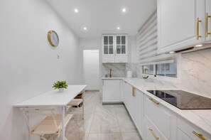 A modern kitchen with white cabinetry, a marble countertop, and a built-in oven. - Apartment 'Ángeles Center' with Balcony and Wi-Fi (Marbella)