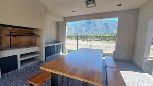 Une cuisine moderne dotée d’un four encastré, d’une table en bois et offrant une vue sur les montagnes grâce à une grande fenêtre.