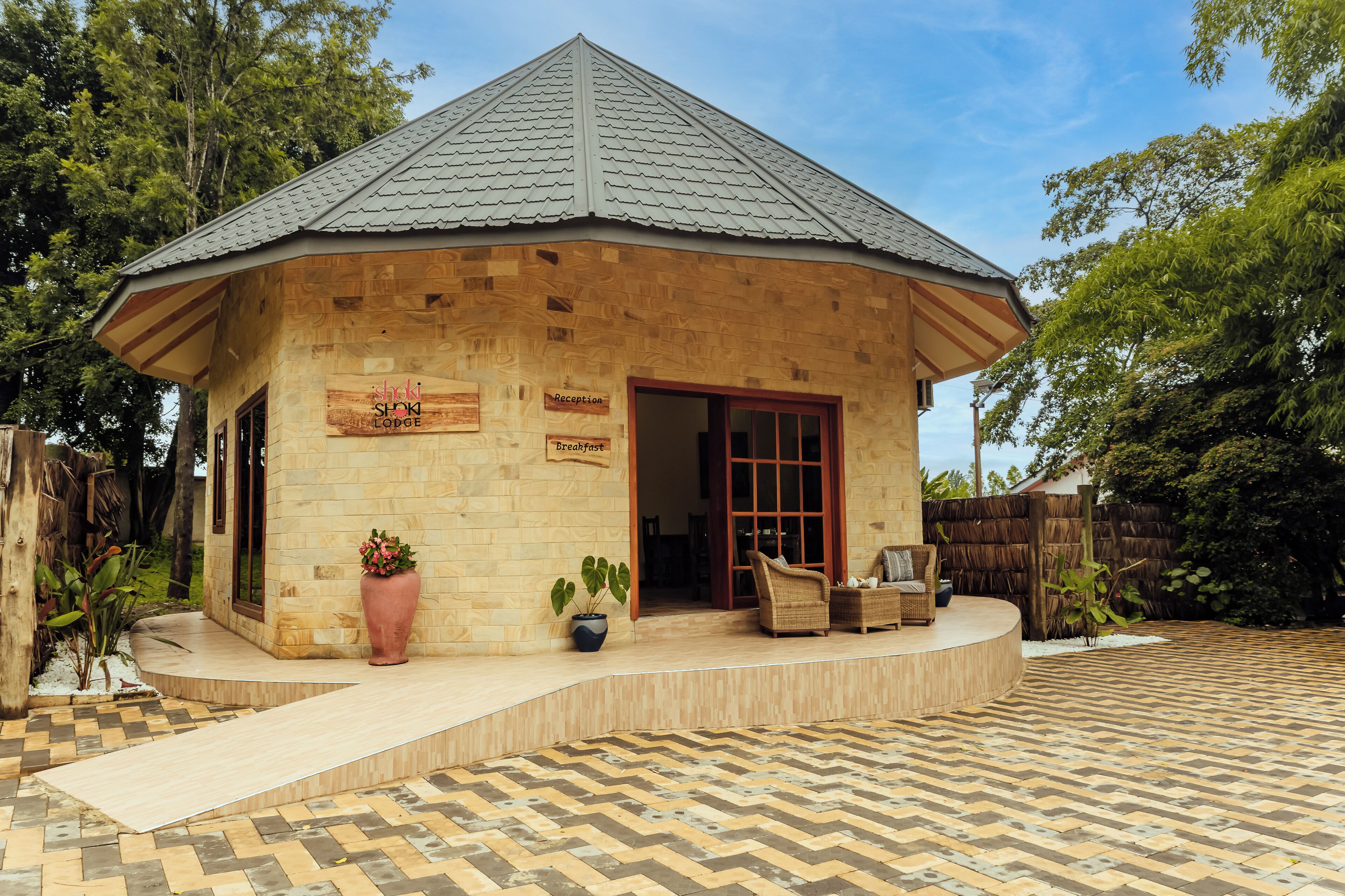 A lodge with a reception area, a breakfast sign, and a seating area with chairs and a table.