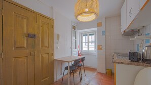 Une cuisine de taille réduite avec une porte en bois, une petite table à manger et des chaises.