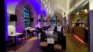 A restaurant with stone arches, wooden tables, and a bar area. - Hotel-Restaurant Bachmühle (Fulda)