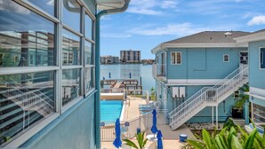A hotel with a pool, a staircase, and a view of the water. - 2BR Waterview Suite on Clearwater Beach w/ Pool (Clearwater)