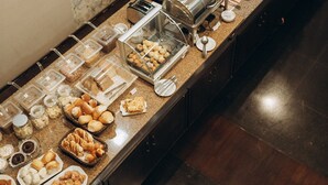 A buffet setup with various food items and a coffee station. - Salvatori Hotel (Telemaco Borba)