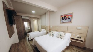 A hotel room with two beds, wooden flooring, a mounted TV, a painting on the wall, and a bedside table with a phone and remote. - Salvatori Hotel (Telemaco Borba)