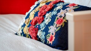 A bed with a floral-patterned pillow and a white pillow. - Setubal Boutique Apartment IV by Homing (Setubal)
