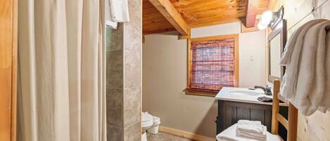 Un baño con ducha, inodoro y lavamanos.