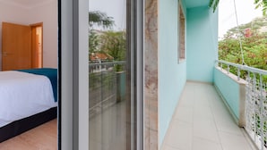A bedroom with a bed, a sliding glass door leading to a balcony with a railing. - Setubal Boutique Apartment II by Homing (Setubal)