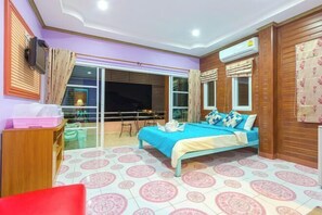 A bedroom with a bed, a window, a ceiling fan, and a wall-mounted air conditioner.