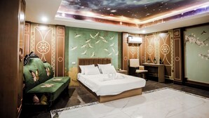 A hotel room with a bed, a sofa, a desk, and a TV. - Underskies Spa and Hotel (Parañaque)