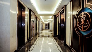 A long, polished hallway with mirrored walls and doors, leading to a central elevator area. - Underskies Spa and Hotel (Parañaque)