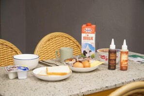 A breakfast table with a carton of milk, condiments, eggs, cheese, and a bowl of cereal. - Kumho Ryokan for Female Travelers – Near Dongdaemun (Seoul)