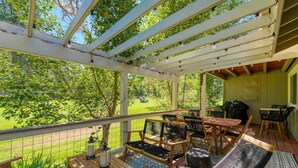 A covered outdoor patio with wooden furniture, a table, and chairs. - Red Fox Retreat - 37 Aspen (Blairsden)