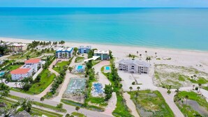 Ein Resort mit mehreren Gebäuden, einem Strand und einem Poolbereich.