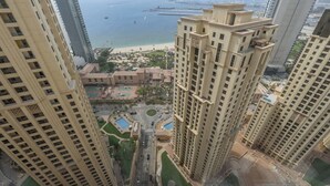 A high-rise residential building with a view of a beach and marina. - StayShort - JBR 2 Bed Apartment sleeps 4 with Sea Views! (Jumeirah Beach Residence)
