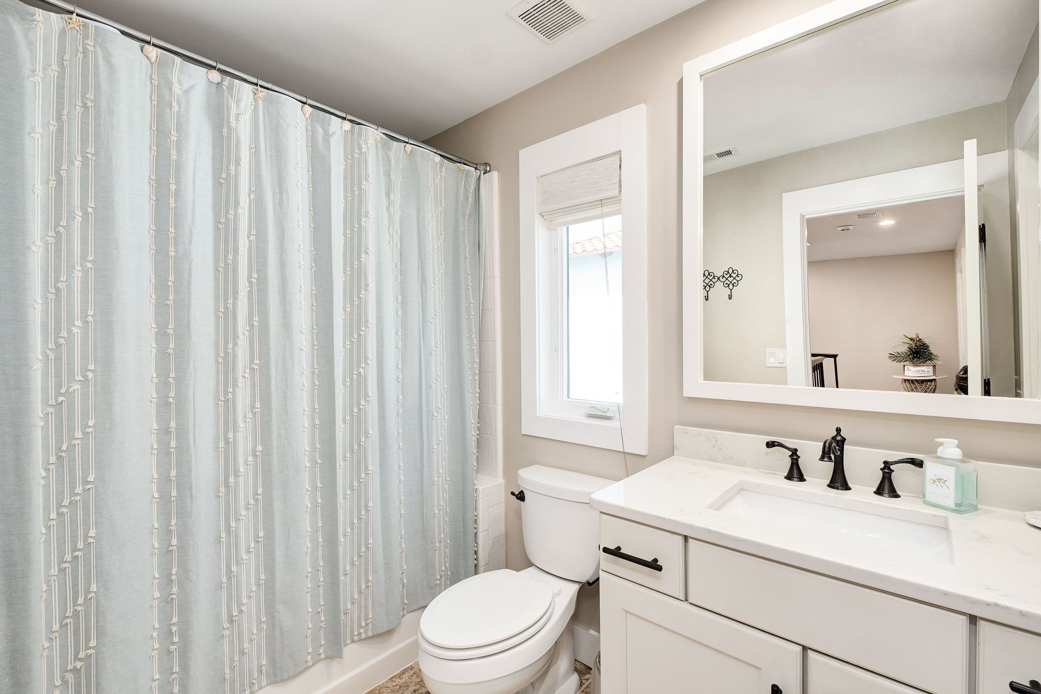 Une salle de bain avec des toilettes, un lavabo et un miroir.