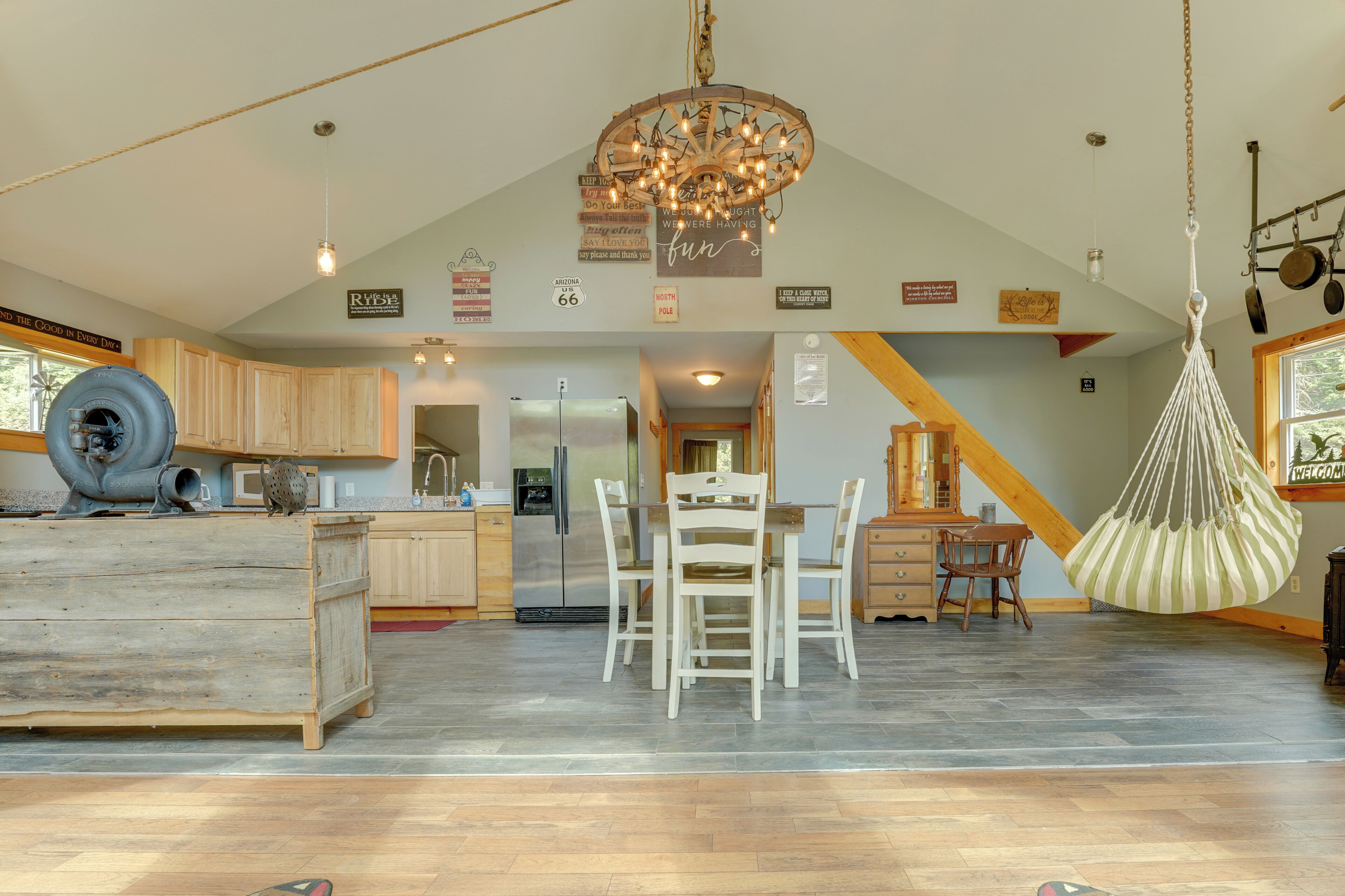A spacious kitchen with wooden cabinets, a central island, and a hanging light fixture.