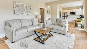 A living room with two sofas, a coffee table, and a kitchen in the background. - Smoky Mtn Getaway: Modern 2br/2ba W/stunning Views (Maggie Valley)
