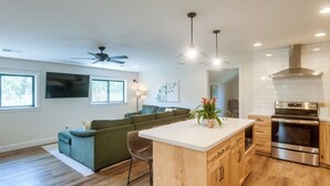 A modern kitchen with a central island, built-in oven, and pendant lighting. - Ski, Hike, Explore: Modern Guest Suite in Rigby (Rigby)