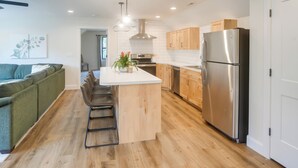 A modern kitchen with a central island, wooden cabinets, and stainless steel appliances. - Ski, Hike, Explore: Modern Guest Suite in Rigby (Rigby)
