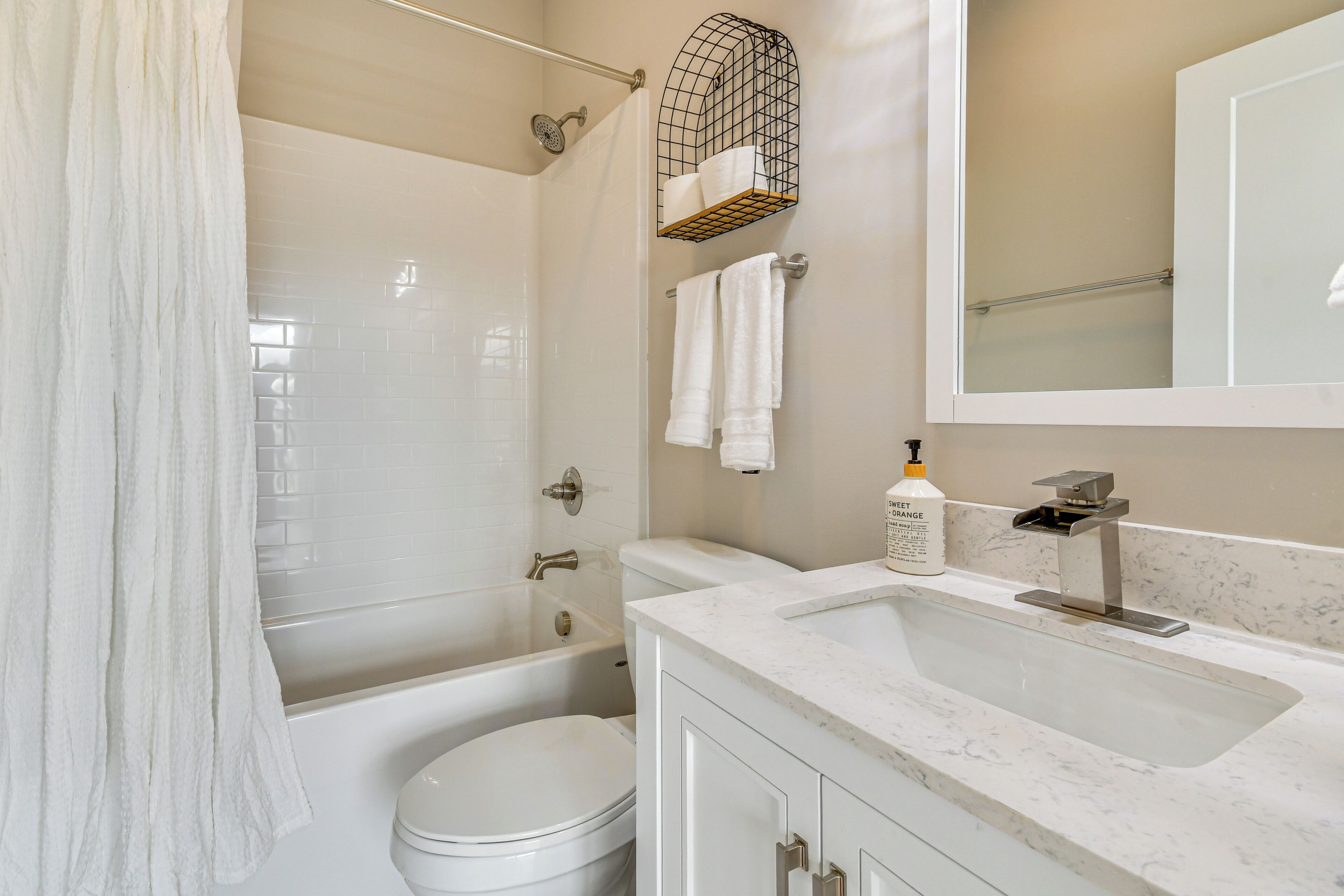 A modern bathroom with a bathtub, toilet, and sink.