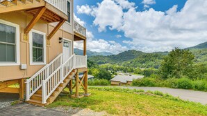 A two-story building with a wooden deck and white railings, overlooking a green valley and mountains. - Cozy 2br/2ba Mtn Escape w/ Views in Maggie Valley (Maggie Valley)