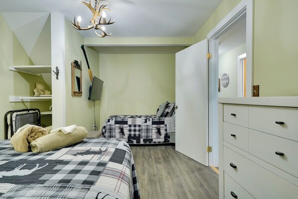 A bedroom with two beds, a wardrobe, a desk, and a mirror. - Waterfront Home on Paradox Lake w/ Dock & Views! (Severance)